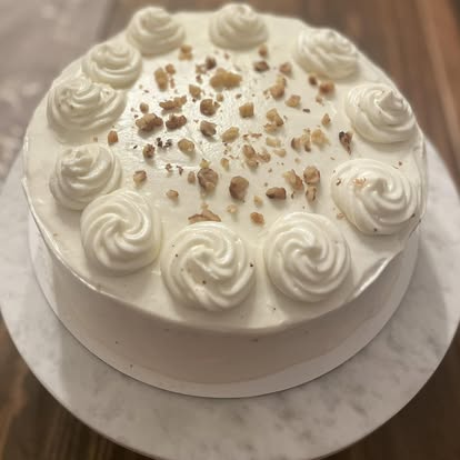 Carrot cake with cream cheese frosting and chopped nuts
